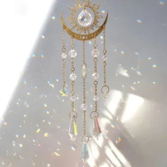 "Crystal Glass Sun & Moon Suncatcher hanging near a window, casting rainbow reflections."
